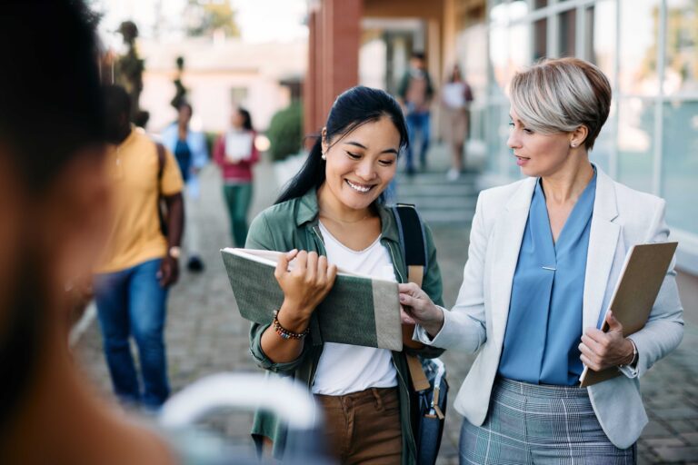 University teacher talking to her Asian female student at campus.